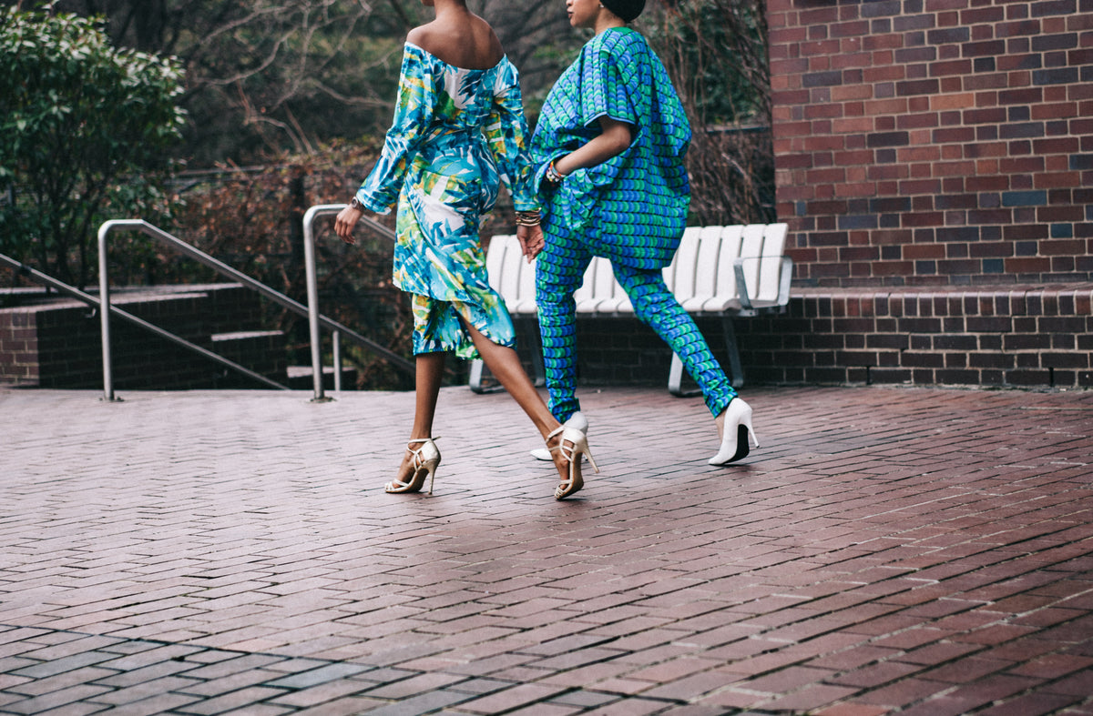 two ladies walking dressed in African clothing
